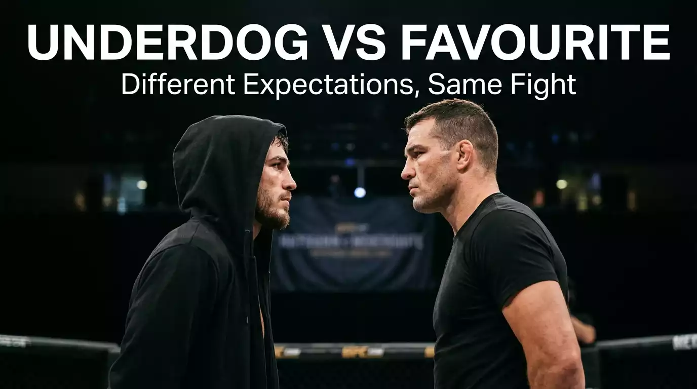 Two UFC fighters in a close staredown with one wearing a hooded walkout robe